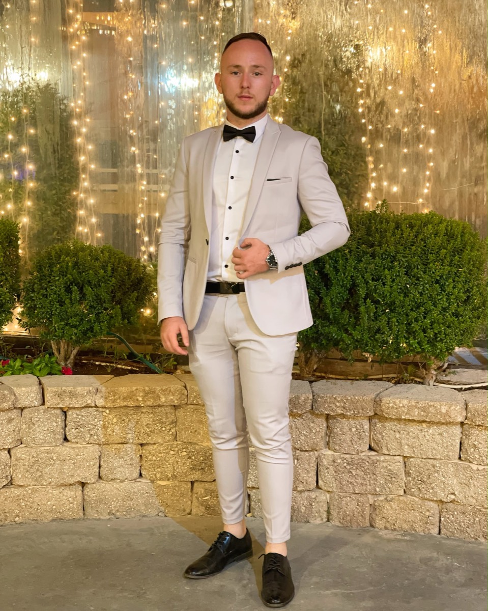 Guy Kaufman in a white tuxedo at an evening event