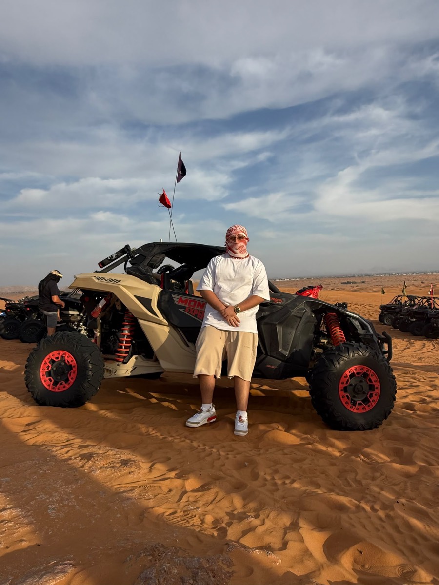 Standing in front of an off-road buggy in the desert